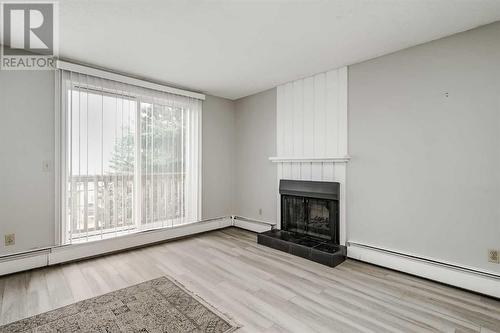 202, 219 Huntington Park Bay Nw, Calgary, AB - Indoor Photo Showing Living Room With Fireplace