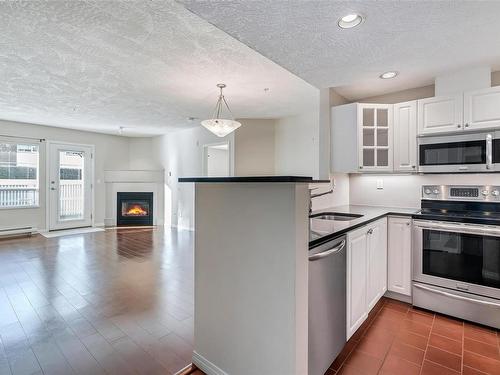 110-380 Waterfront Cres, Victoria, BC - Indoor Photo Showing Kitchen With Fireplace