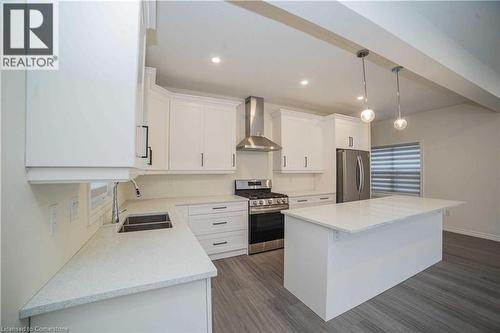 Kitchen featuring wall chimney exhaust hood, stainless steel appliances, sink, white cabinets, and a center island - 182 Byers Street, London, ON - Indoor Photo Showing Kitchen With Double Sink With Upgraded Kitchen