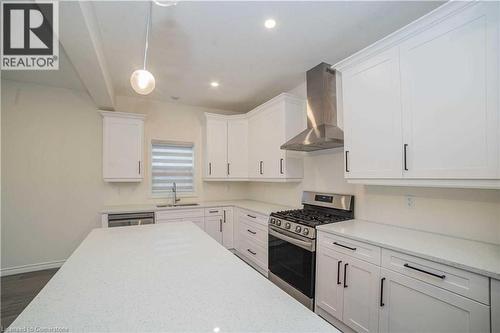 Kitchen featuring white cabinets, sink, wall chimney range hood, and stainless steel appliances - 182 Byers Street, London, ON - Indoor Photo Showing Kitchen