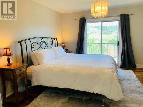 Primary bedroom with attached deck - 573 Spruceview Place N, Kelowna, BC - Indoor Photo Showing Bedroom