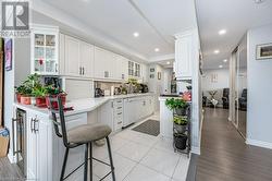 Kitchen with white dishwasher, white cabinetry, light hardwood / wood-style flooring, and tasteful backsplash - 