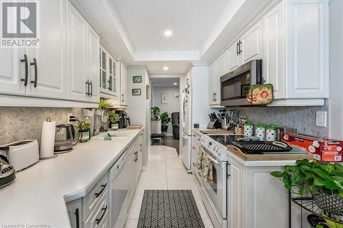 Kitchen with white cabinets, light tile patterned floors, white appliances, and sink - 3100 Kirwin Avenue Unit# 2102, Mississauga, ON - Indoor Photo Showing Kitchen With Upgraded Kitchen