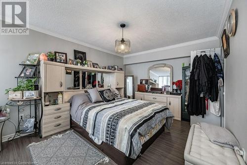 Bedroom with crown molding, dark wood-type flooring, and a textured ceiling - 3100 Kirwin Avenue Unit# 2102, Mississauga, ON - Indoor Photo Showing Bedroom