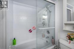 Bathroom with bath / shower combo with glass door and toilet - 