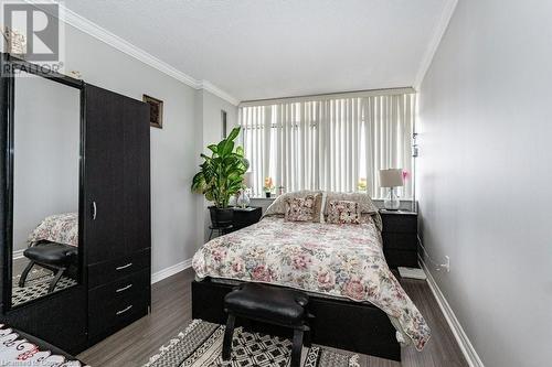 Bedroom with dark hardwood / wood-style flooring, a textured ceiling, and ornamental molding - 3100 Kirwin Avenue Unit# 2102, Mississauga, ON - Indoor Photo Showing Bedroom