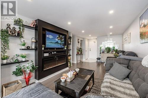 Living room featuring a large fireplace and wood-type flooring - 3100 Kirwin Avenue Unit# 2102, Mississauga, ON - Indoor Photo Showing Living Room