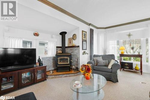 Carpeted living room with a wood stove and crown molding - 30 Kenneth Boulevard, Quinte West, ON - Indoor Photo Showing Living Room With Fireplace