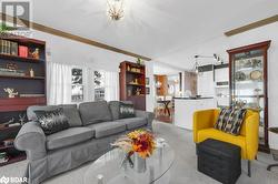 Living room with light colored carpet, ornamental molding, and a chandelier - 