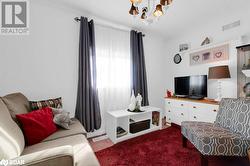 Carpeted living room featuring crown molding and a notable chandelier - 