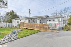 Ranch-style home featuring a wooden deck and a front lawn - 