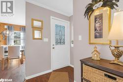 Entrance foyer featuring dark hardwood / wood-style floors and crown molding - 