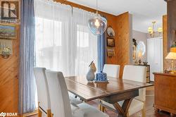 Dining room featuring a chandelier, dark hardwood / wood-style floors, and wooden walls - 