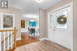 Foyer with a textured ceiling, light hardwood / wood-style floors, crown molding, and a healthy amount of sunlight - 