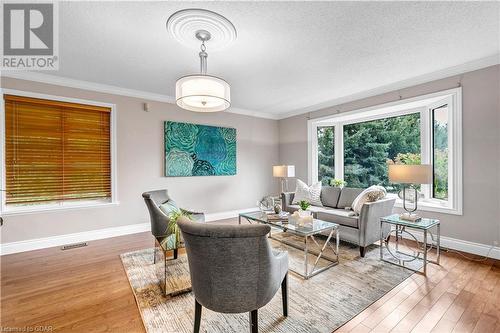 Living room featuring wood-type flooring, a textured ceiling, and crown molding - 5819 Wellington Cty Rd 7, Guelph, ON 