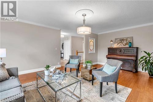 Living room featuring light hardwood / wood-style floors, a textured ceiling, and ornamental molding - 5819 Wellington Cty Rd 7, Guelph, ON 