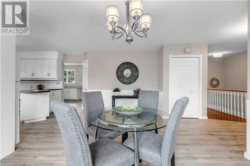 Dining space featuring a notable chandelier and light wood-type flooring - 5819 Wellington Cty Rd 7, Guelph, ON 