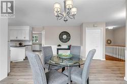 Dining space featuring a notable chandelier and light wood-type flooring - 