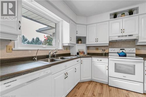 Kitchen with white cabinetry, white appliances, and light hardwood / wood-style flooring - 5819 Wellington Cty Rd 7, Guelph, ON 