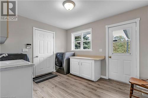 Laundry area with plenty of natural light, cabinets, and light hardwood / wood-style flooring - 5819 Wellington Cty Rd 7, Guelph, ON 