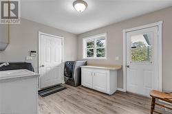 Laundry area with plenty of natural light, cabinets, and light hardwood / wood-style flooring - 