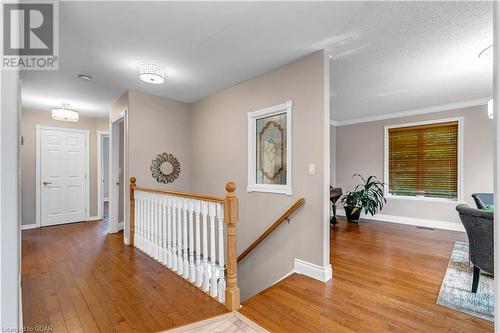 Hall featuring a textured ceiling, light wood-type flooring, and crown molding - 5819 Wellington Cty Rd 7, Guelph, ON 