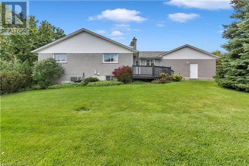 Rear view of house with a yard, a deck, and central AC unit - 5819 Wellington Cty Rd 7, Guelph, ON 