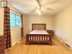 Bedroom featuring ceiling fan and light wood-type flooring - 