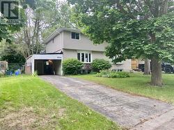 View of front of house with a carport and a front lawn - 