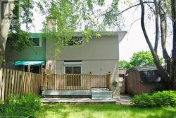 Back of house featuring a storage unit and a deck - 