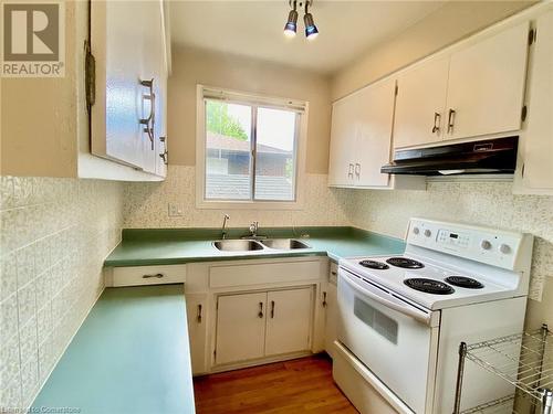 Kitchen with white electric range, light hardwood / wood-style flooring, white cabinetry, and sink - 531 Brookhaven Crescent Unit# A, Waterloo, ON - Indoor Photo Showing Kitchen With Double Sink