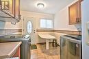 Clothes washing area with light tile patterned flooring, cabinets, and washing machine and clothes dryer - 1476 Barton Street E, Hamilton, ON  - Indoor Photo Showing Laundry Room 