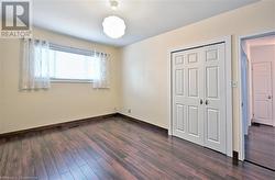 Unfurnished bedroom with dark hardwood / wood-style flooring and a closet - 