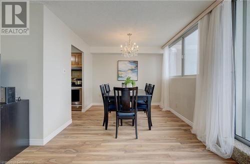 Dining area with a chandelier and light hardwood / wood-style floors - 375 King Street N Unit# 503, Waterloo, ON - Indoor Photo Showing Dining Room