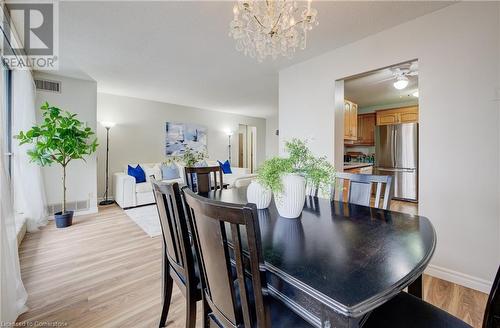 Dining space featuring ceiling fan with notable chandelier and light wood-type flooring - 375 King Street N Unit# 503, Waterloo, ON - Indoor Photo Showing Dining Room