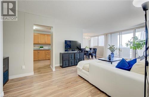 Living room featuring light wood-type flooring and an inviting chandelier - 375 King Street N Unit# 503, Waterloo, ON - Indoor