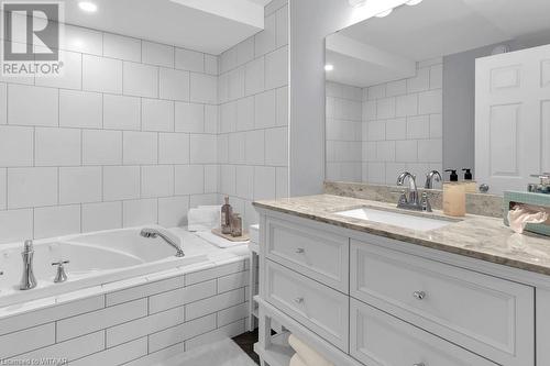 Bathroom featuring vanity and tiled tub - 529 Nova Scotia Court Unit# 18, Woodstock, ON - Indoor Photo Showing Bathroom