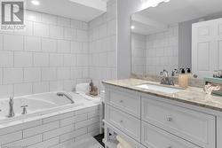 Bathroom featuring vanity and tiled tub - 