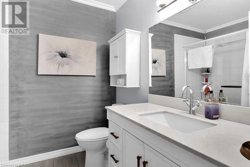 Bathroom featuring vanity, crown molding, toilet, tile walls, and wood-type flooring - 529 Nova Scotia Court Unit# 18, Woodstock, ON - Indoor Photo Showing Bathroom