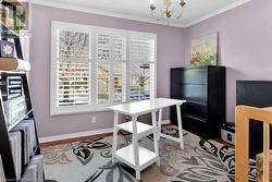 Home office featuring crown molding, light hardwood / wood-style flooring, and a notable chandelier - 