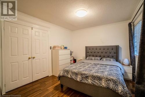 Bedroom with a textured ceiling, crown molding, a closet, and dark wood-type flooring - 1480 Britannia Road W Unit# 143, Mississauga, ON - Indoor Photo Showing Bedroom