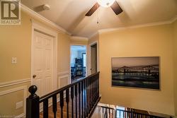 Hall featuring wood-type flooring, a textured ceiling, and crown molding - 