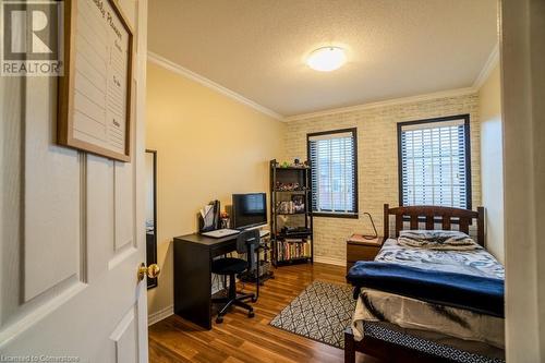 Bedroom featuring a textured ceiling, dark hardwood / wood-style floors, ornamental molding, and brick wall - 1480 Britannia Road W Unit# 143, Mississauga, ON - Indoor Photo Showing Bedroom