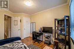 Office space featuring hardwood / wood-style floors, a textured ceiling, and ornamental molding - 