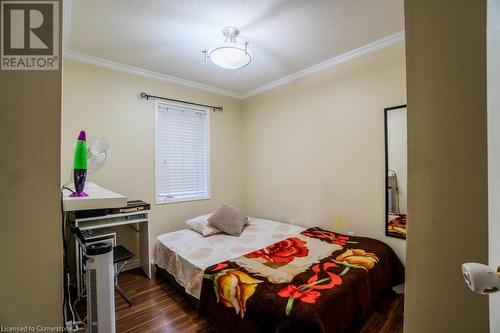 Bedroom with a textured ceiling, ornamental molding, and dark wood-type flooring - 1480 Britannia Road W Unit# 143, Mississauga, ON - Indoor Photo Showing Bedroom