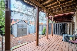 Wooden deck featuring a shed and central air condition unit - 