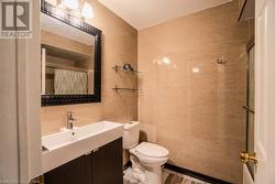 Bathroom featuring vanity, toilet, and tile walls - 