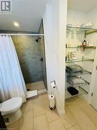 Bathroom with tile patterned floors, toilet, and walk in shower - 