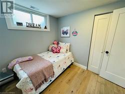 Bedroom with a closet, light hardwood / wood-style flooring, and a baseboard heating unit - 