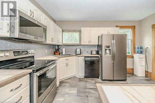 Kitchen featuring tasteful backsplash, white cabinetry, plenty of natural light, and stainless steel appliances - 3212 Roseville Road, Roseville, ON - Indoor Photo Showing Kitchen With Double Sink